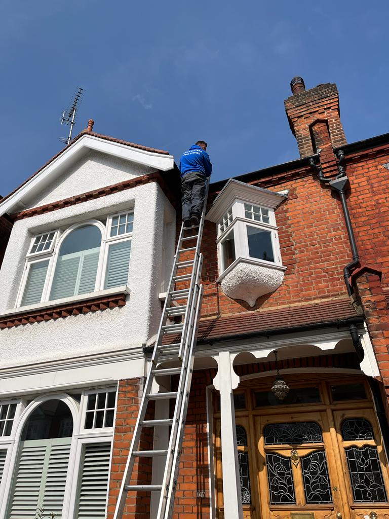 Sam's Gutters technician clearing out a gutter