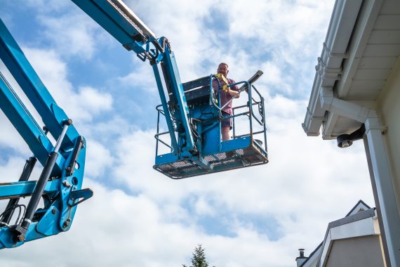 technicians on cherry picker for commercial gutter clean